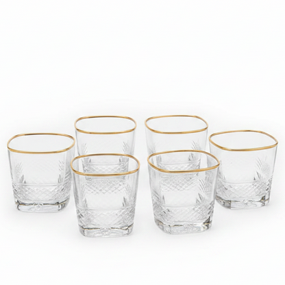 Luxury gold rim crystal glass tumbler set with a stainless steel holder on a dining table