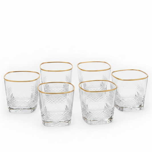 Luxury gold rim crystal glass tumbler set with a stainless steel holder on a dining table