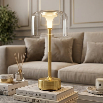 Brass minimalist glass shade LED table lamp lit on marble table in cozy room