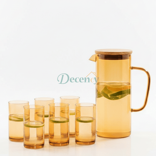 Modern  glass water pitcher set displayed on a kitchen counter next to breakfast pastries.
