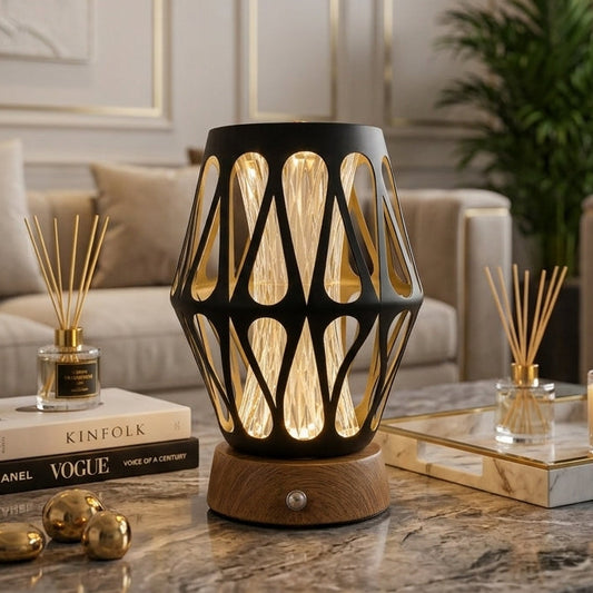 Modern black cutout LED table lamp with a wooden base sitting on a marble coffee table.