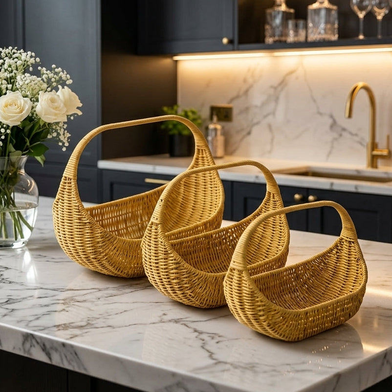 Set of 3 oval-shaped woven rattan storage baskets with handles on a marble kitchen counter
