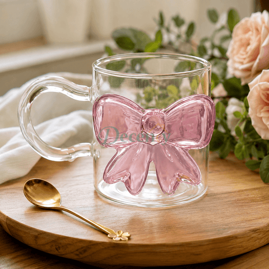 Clear glass mug featuring a 3D pink glass bow motif on a wooden platter.   