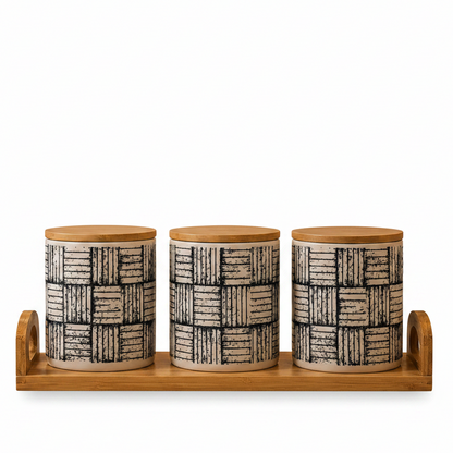 Three plaid pattern ceramic kitchen storage canisters arranged neatly on a wooden tray.