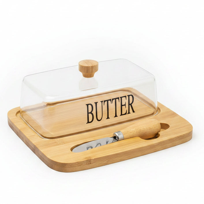 Rectangular clear glass butter dish with lid sitting on a wooden bamboo serving tray