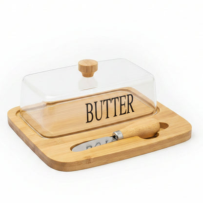 Rectangular clear glass butter dish with lid sitting on a wooden bamboo serving tray