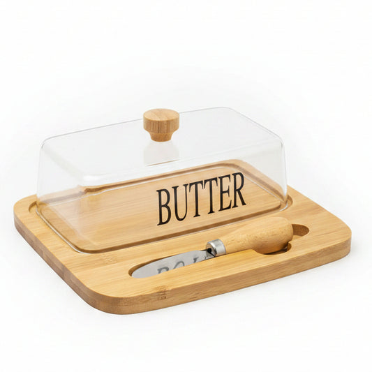 Rectangular clear glass butter dish with lid sitting on a wooden bamboo serving tray