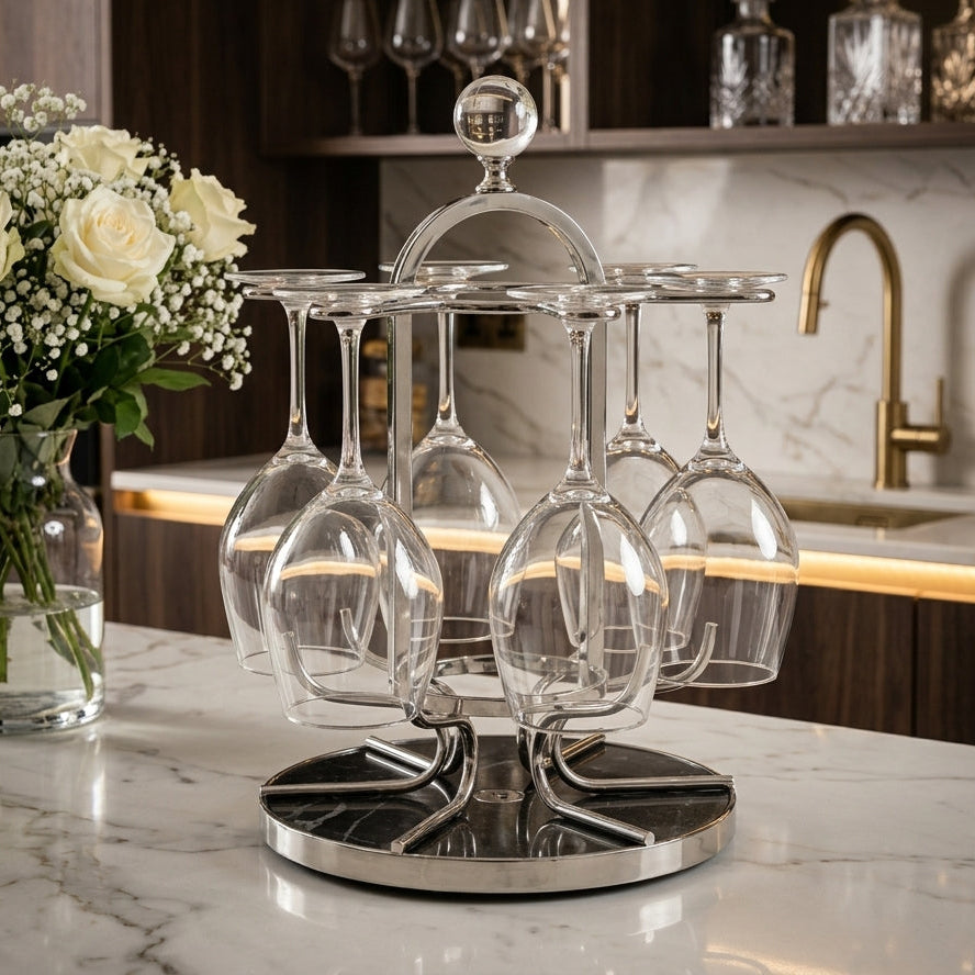 Front view of a chrome revolving glass holder rack on a marble base holding upside-down stemmed glasses