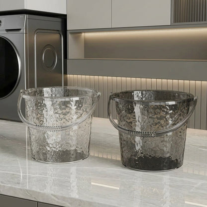 Clear and smoke grey transparent plastic water buckets with hammered texture on counter