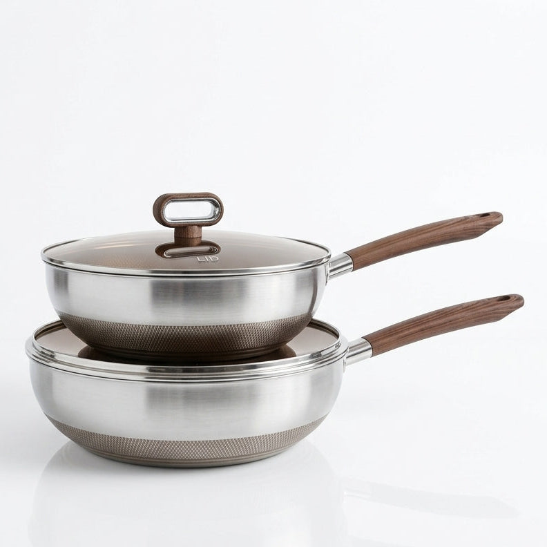 Stacked stainless steel non-stick wok and frying pan set with heat-resistant wooden handles against a white background.