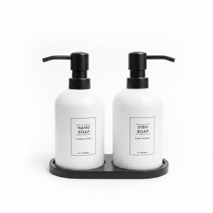 White ceramic hand soap and dish soap dispenser set sitting on a black tray.